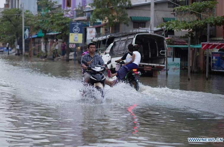 Người dân lái xe gắn máy băng qua con đường ngập nước ở Mandalay, Myanmar ngày 21/8. Trận lũ lụt ở Myanmar bắt đầu từ hồi giữa tháng 7/2016 hiện vẫn còn ảnh hưởng nặng nề tới các vùng như Bago, Ayeyawaddy và Yangon.